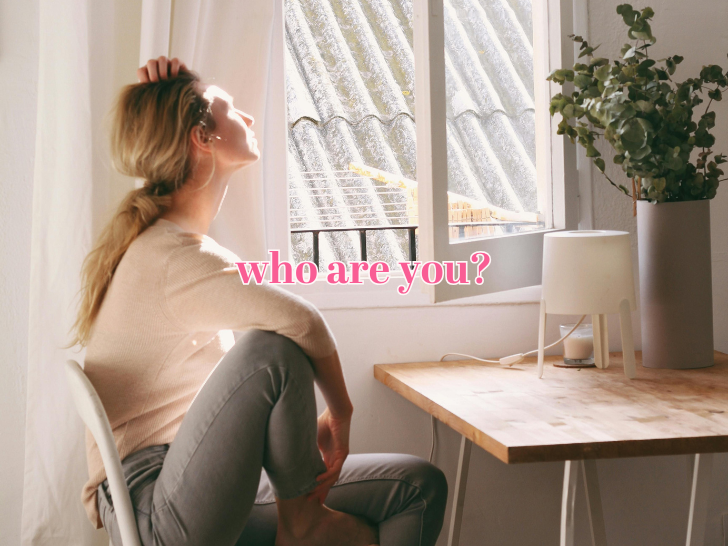 women sitting at a table, knee up, head resting on hand, looking out an open window