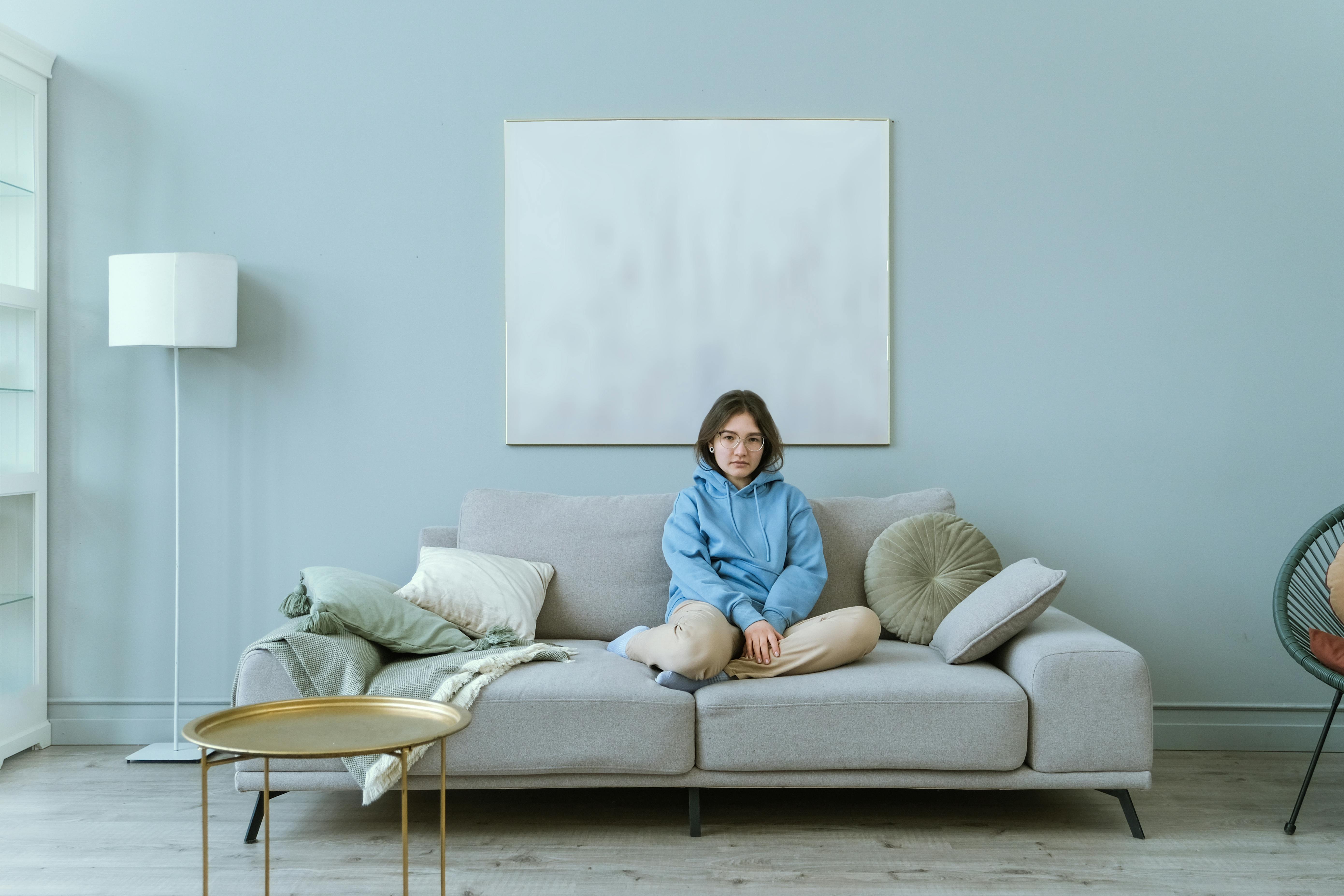 women sitting on couch in simple blue aesthetic living room